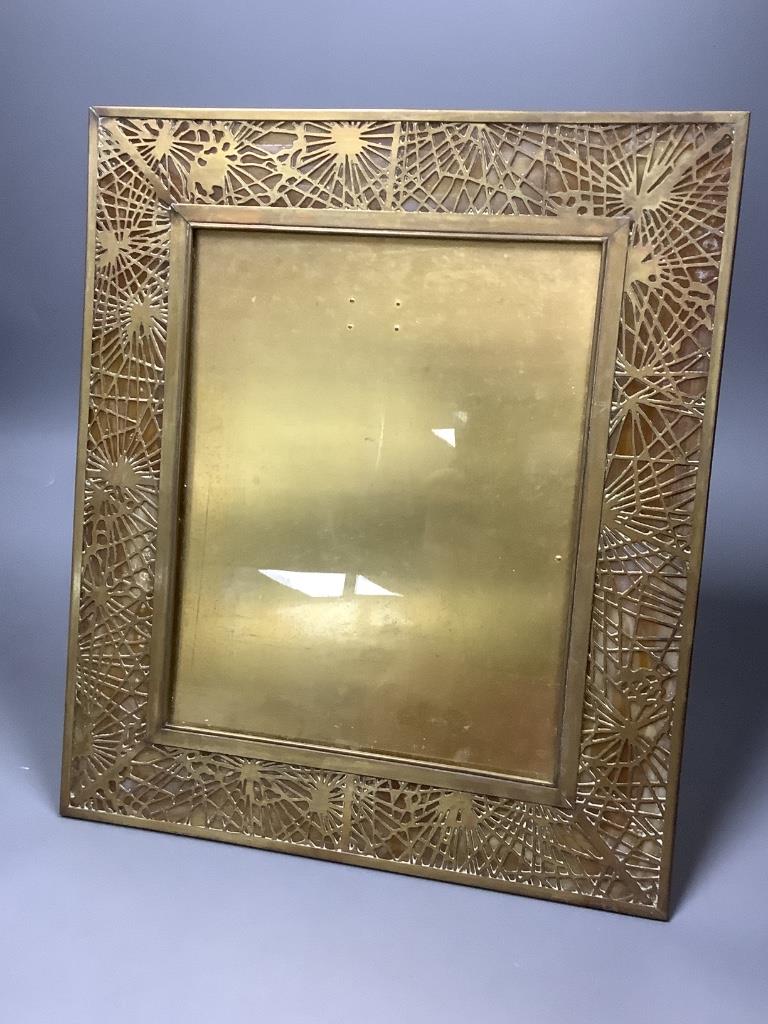 A Tiffany Studio's pierced gilt brass and mottled glass photograph frame, stamped to reverse 'Tiffany Studios, New York 916', overall 36 x 31cm
